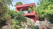 Maison passive contemporaine à l'enduit rouge terra cotta, réalisée par PHC à Saint-Laurent-du-Var (06123) près de Nice